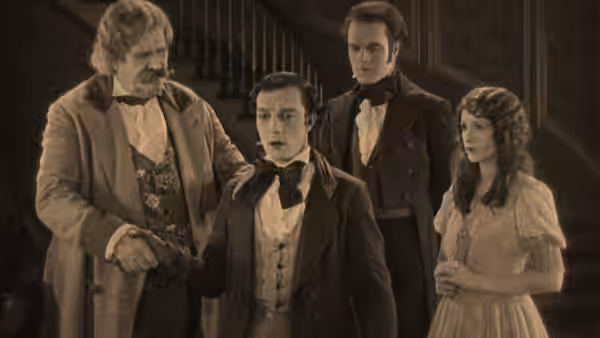Joseph Canfield (Joe Roberts) shakes hands with William McKay (Buster Keaton) as Clayton and Virginia watch