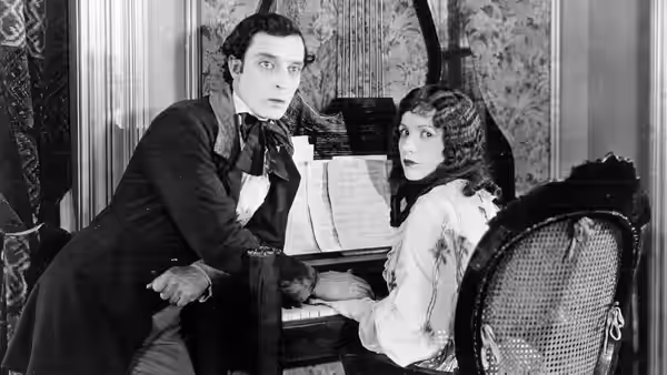 William McKay (Buster Keaton) and Virginia Canfield (Natalie Talmadge) sit together at a desk