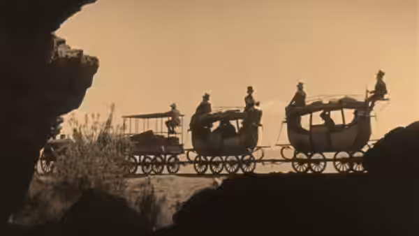 Passengers ride a steam train across a trestle bridge above a rocky ravine