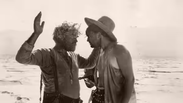 John McTeague (Gibson Gowland) confronts Marcus (Jean Hersholt) on a barren shore