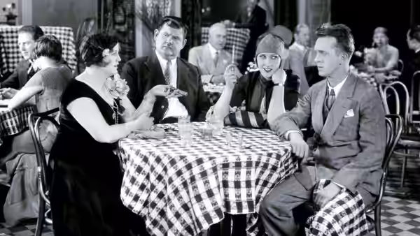 Jimmie Shannon (Buster Keaton) sits at a restaurant table with several companions
