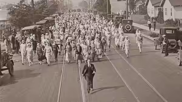 Jimmie Shannon (Buster Keaton) runs down a street as a crowd pursues him