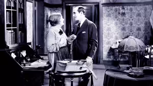 A woman and a suited man stand together beside an open suitcase
