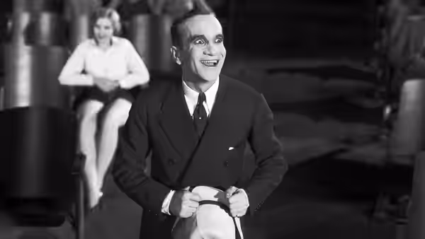 Jakie Rabinowitz (Al Jolson) sits smiling with a woman behind him