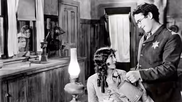 Harold Hickory (Harold Lloyd) shows Mary Powers (Jobyna Ralston) a paper inside a room