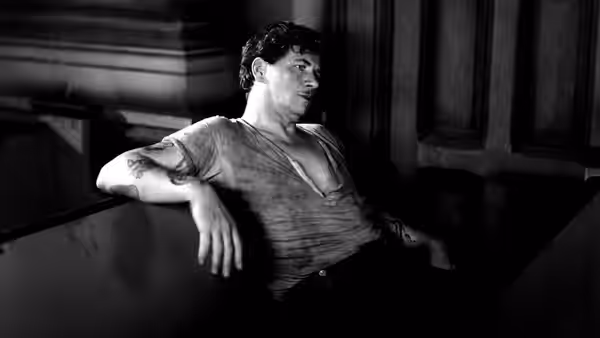 Bill Roberts (George Bancroft) reclines against a wall in an open-necked shirt
