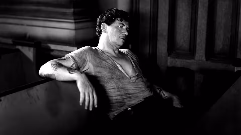 Bill Roberts (George Bancroft) reclines against a wall in an open-necked shirt
