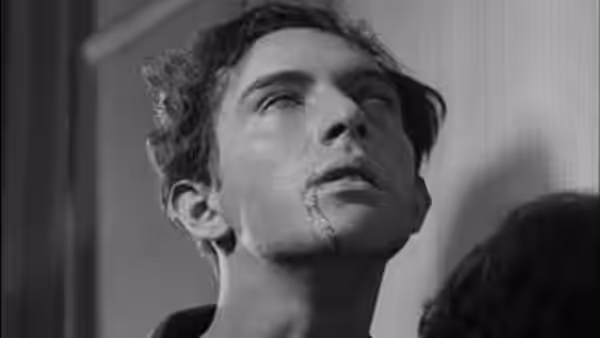 The man tilts his head back, eyes rolled upward and lips parted