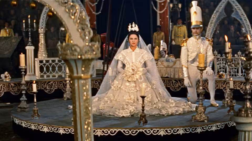 Lola Montes (Martine Carol) stands in a bridal gown beside a groom at an ornate altar