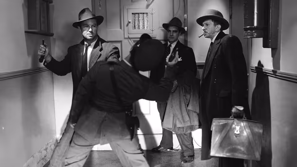 Several suited men gather in a hallway, one holding a suitcase