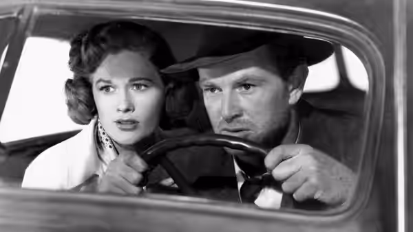 Doll Conovan (Jean Hagen) sits beside Dix Handley (Sterling Hayden) at the steering wheel