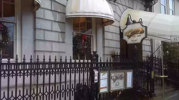 The exterior of the Cheers bar with sign, awning and fence