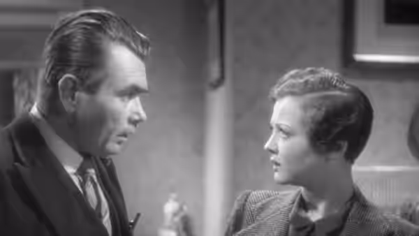 Karl Verloc (Oskar Homolka) faces Mrs. Verloc (Sylvia Sidney) in conversation