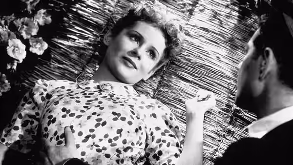 Françoise (Jacqueline Laurent) lies on a woven mat as François watches