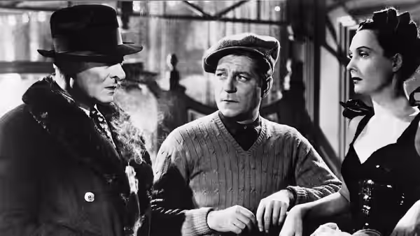 M. Valentin (Jules Berry), Gaston (Bernard Blier) and Clara (Arletty) stand together indoors