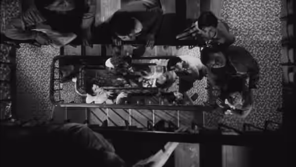 Several people lean over a man lying on a table