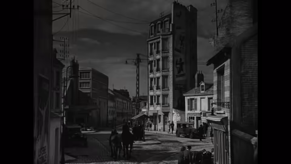 Pedestrians cross a quiet street lined with tall apartment buildings