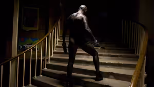 Charles Bronson (Tom Hardy) climbs a dimly lit staircase, seen from behind