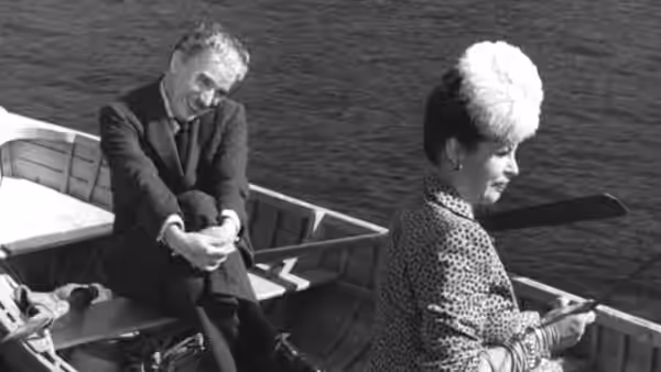 Henri Verdoux (Charlie Chaplin) reaches toward a woman beside him on a boat