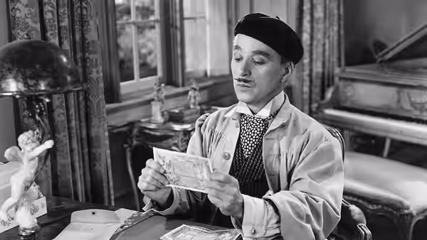 Henri Verdoux (Charlie Chaplin), wearing a beret, reads a letter at his desk