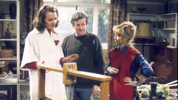 Margo Leadbetter gesturing as she speaks to Jerry Leadbetter and Barbara Good indoors
