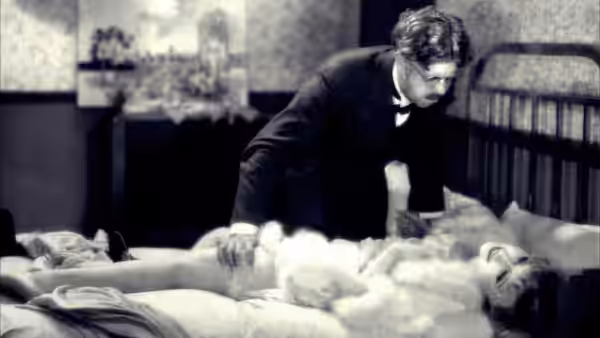 Maurice Legrand (Michel Simon) leans over a woman lying on a bed