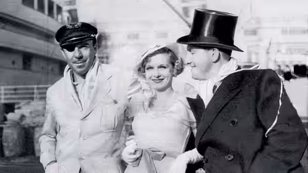 Danny Dolan (Spencer Tracy) and Helen Riley (Joan Bennett) stand beside a man in a top hat
