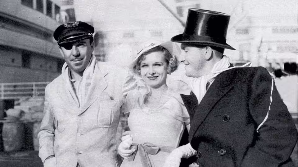 Danny Dolan (Spencer Tracy) and Helen Riley (Joan Bennett) stand beside a man in a top hat