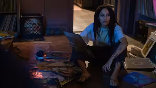 Robyn Brooks (Zoë Kravitz) sits on the floor with a laptop amid records