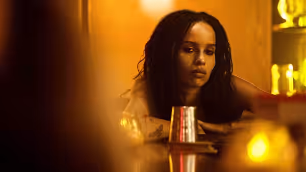 Robyn Brooks (Zoë Kravitz) sits alone at a warmly lit bar