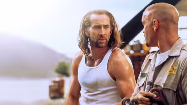 Cameron Poe (Nicolas Cage) talks with a uniformed marshal beside an aircraft