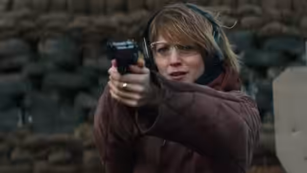 Stephanie Patrick (Blake Lively) aims a handgun in front of a stone wall