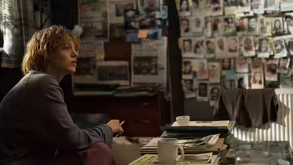 Stephanie Patrick (Blake Lively) studies a wall of photographs from her desk