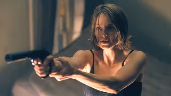 Meg Altman (Jodie Foster) aims a handgun from inside the house
