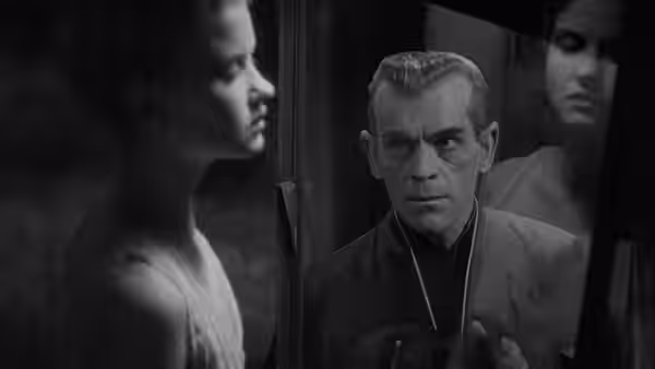 Hjalmar Poelzig (Boris Karloff) looks toward a woman in white, with a man behind him