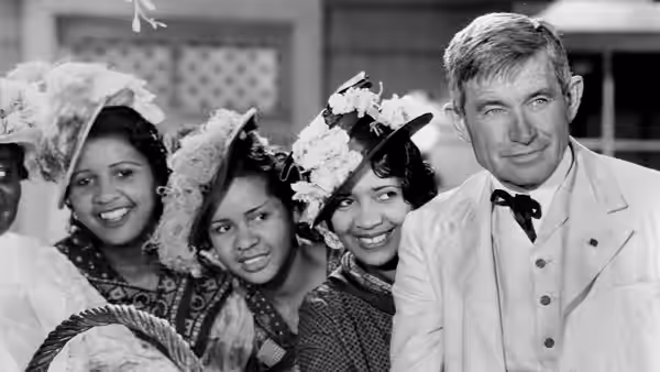 Judge William Pitman 'Billy' Priest (Will Rogers) stands beside three women wearing elaborate hats