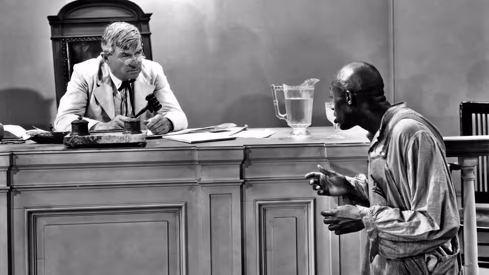 Judge William Pitman 'Billy' Priest (Will Rogers) listens as a man addresses him at the bench