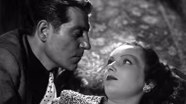 Pépé le Moko (Jean Gabin) leans close as Gaby (Mireille Balin) looks up at him