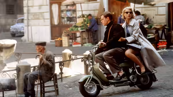 Marge Sherwood (Gwyneth Paltrow) rides on a scooter through a market