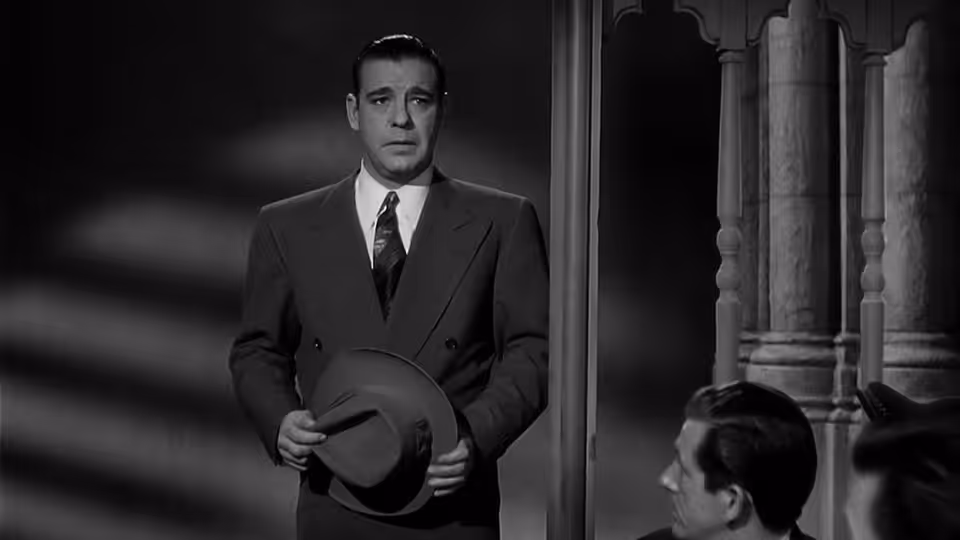 Larry Talbot (Lon Chaney Jr.) stands in a doorway holding his hat
