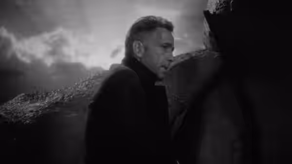 Roy Earle (Humphrey Bogart) stands on a rocky mountainside facing another person