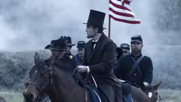Abraham Lincoln (Daniel Day-Lewis) on horseback with Union soldiers and a flag
