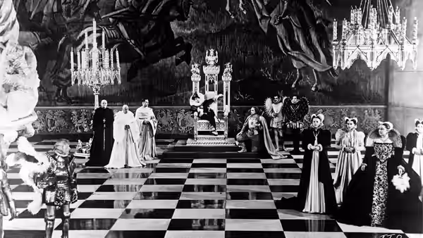 Courtiers gather across a checkerboard floor beneath a decorated canopy