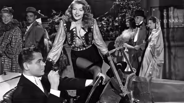 Gilda (Rita Hayworth) stands beside Johnny Farrell (Glenn Ford) in a nightclub