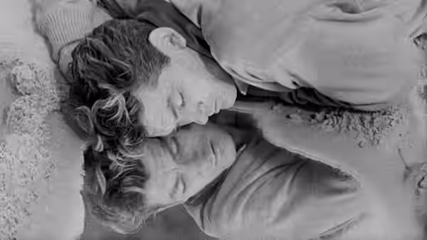 A woman and a man lie face-to-face, their eyes closed