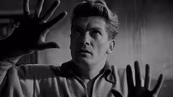 Orphée (Jean Marais) raises his hands and looks upward