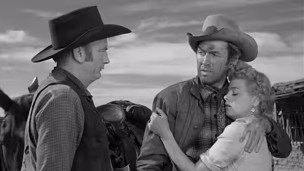 Lin McAdam (James Stewart) holds Lola Manners (Shelley Winters) as a cowboy faces them