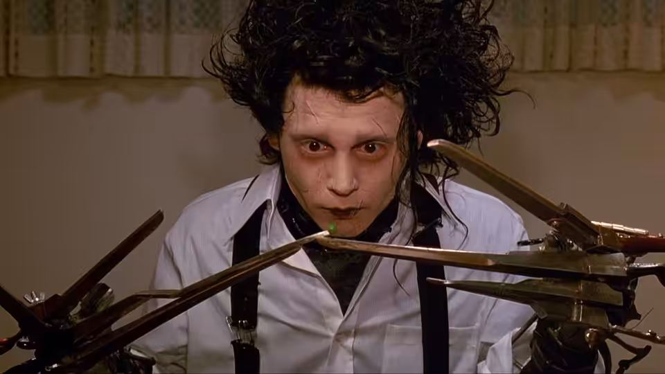 Edward Scissorhands (Johnny Depp) staring ahead with scissor hands raised