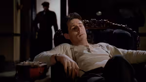 Tom Reagan (Gabriel Byrne) reclining in an armchair looking upward at night