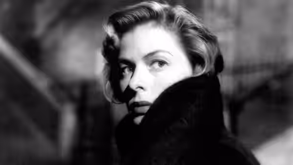 Irene Girard (Ingrid Bergman) gazes ahead with her coat collar raised around her face